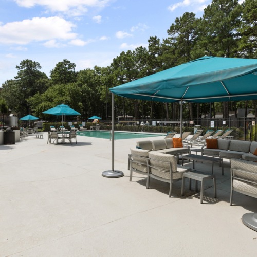 Swimming Pool Large sparkling blue pool with a large pool deck and lounge chairs at Lofts at North Hills Apartments in Raleigh, NC