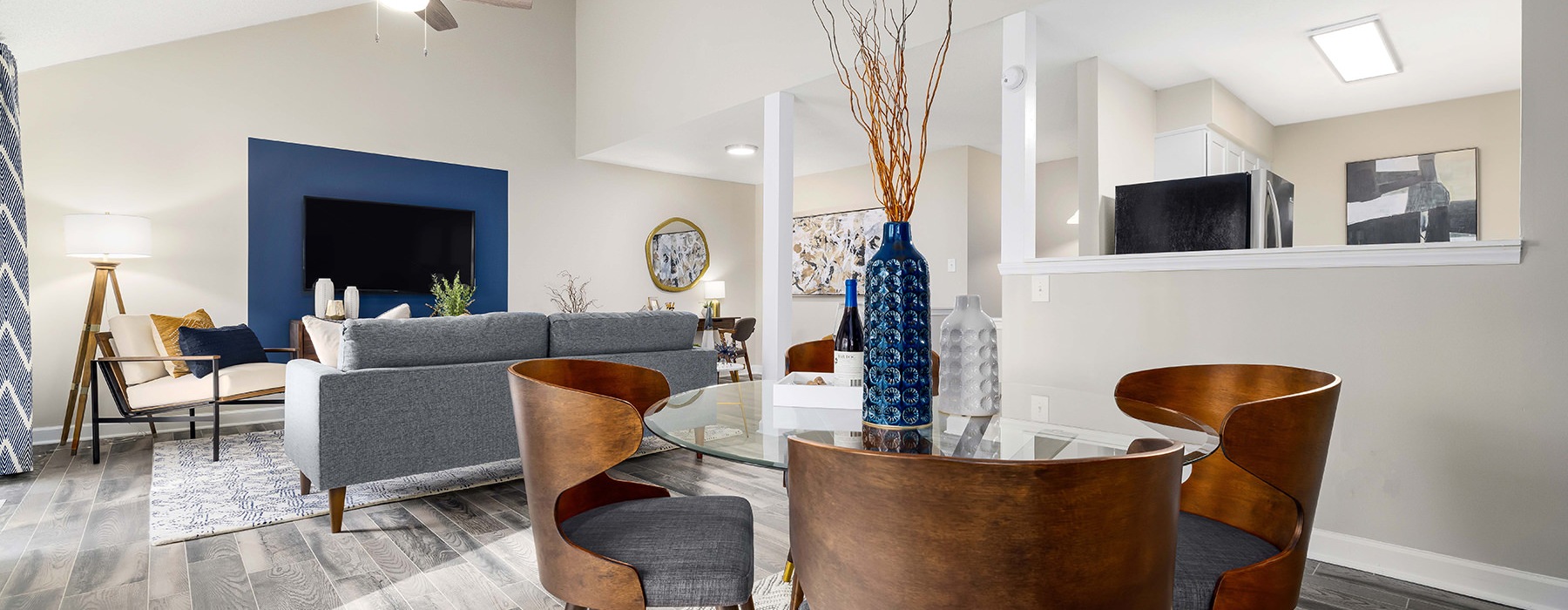 a living room and dining room with a tv, couch, tables and chairs